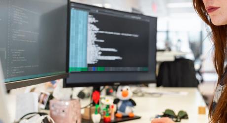 Woman coding on a desktop computer