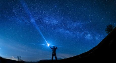 Tour guide pointing a torch into the sky