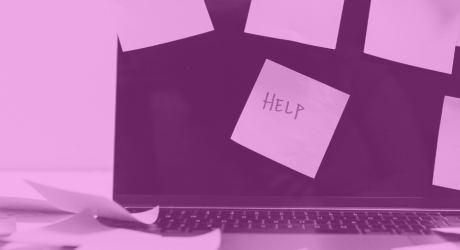 A laptop with a post-it note on the screen saying "Help"