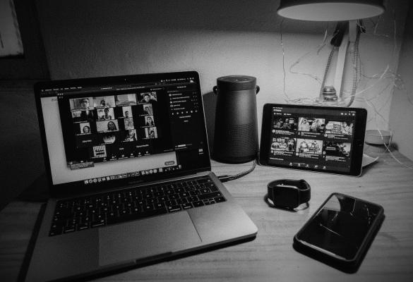 A laptop and tablet showing an online meeting